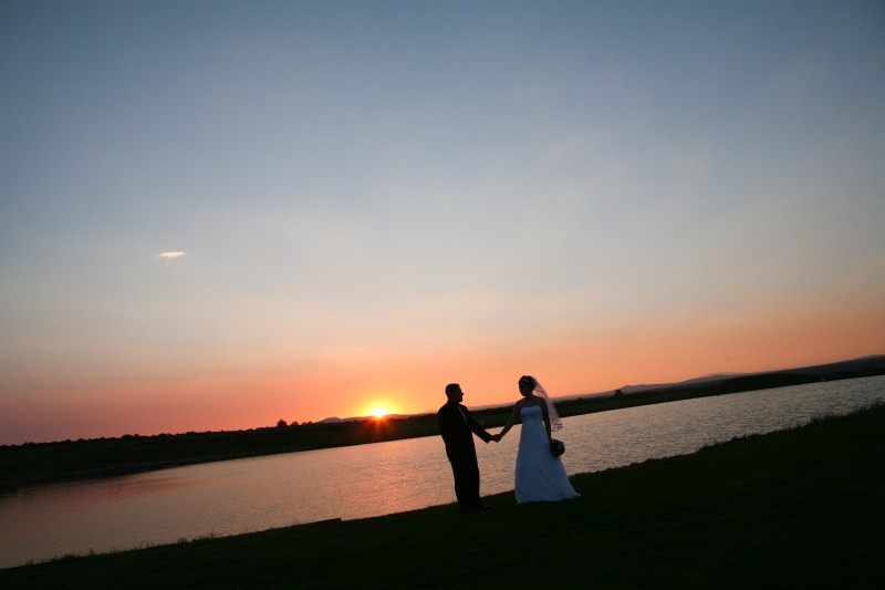 bride and groom at sunset with pond