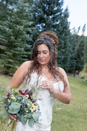 Catrina pulls three tiny daisies out of her bouquet to wear in her hair for photos