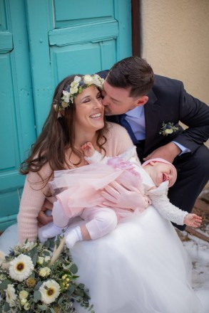 bride and groom laughing with baby having meltdown