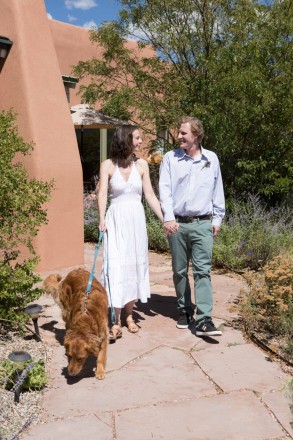 Bride, groom, and a loved family dog with New Mexico landscape