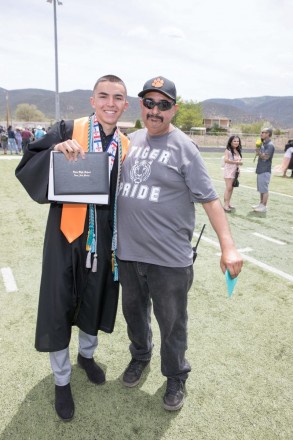 Matthew holds up his diploma after Taos High School graduation