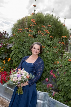 Bride in blue stands with Lion Tail flowers at SpiriTaos