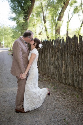 The bride and groom, latilla fence and Cottonwood trees in Taos