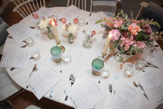 Wedding dinner table adorned with fresh flowers, candles, and wine goblets