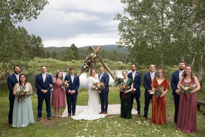 Wedding party in Taos Canyon with navy suits and various colored dresses