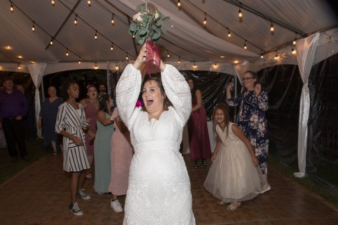 Scarlet throws her bouquet to the single ladies at her wedding