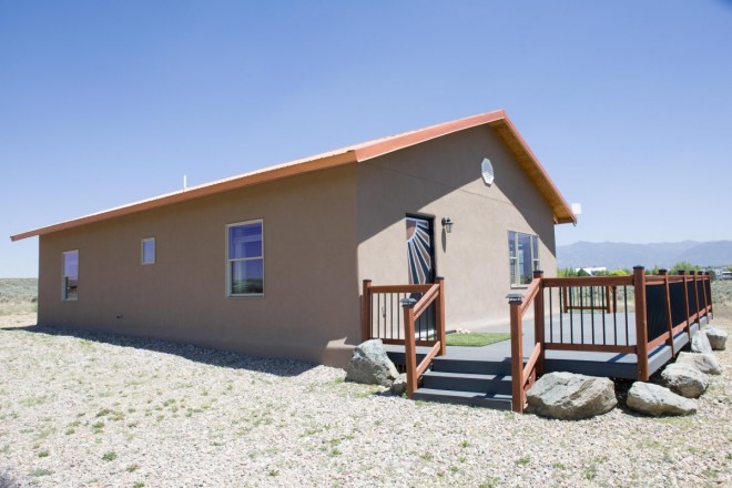 Two bedroom stucco home with porch on four acres of land in Taos, NM