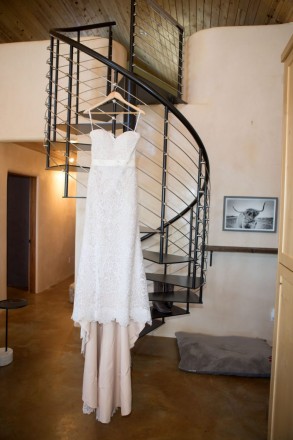 Wedding dress hanging on stairs in home on mesa in El Prado