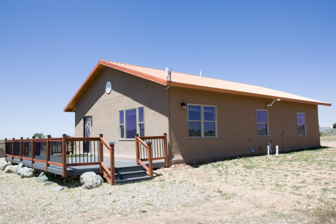 Real estate photo of exterior of stucco home in Taos high desert