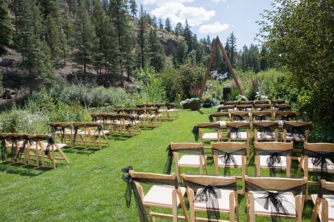 Mountain wedding outdoor ceremony with triangle arch and black bows
