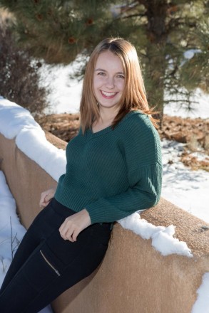 Bryna in a green sweater for her insanely cold senior session outdoors in January in Taos.