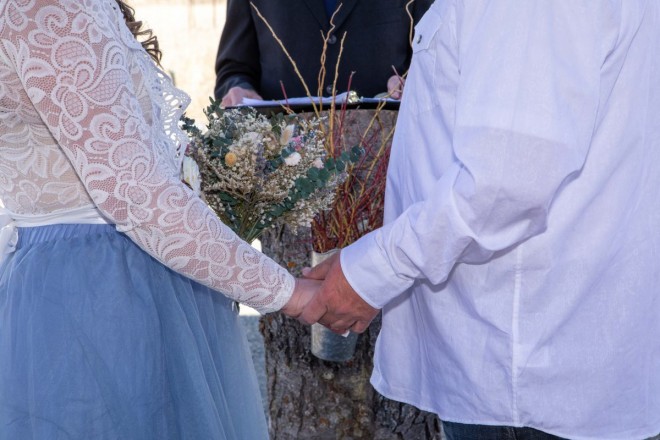 Bride and groom hold hands during their Taos wedding in springtime