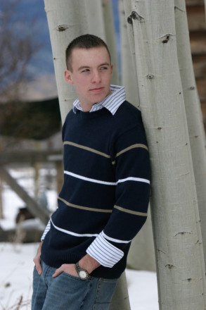 Matthew leans against an aspen near sunset at senior photo shoot in Taos