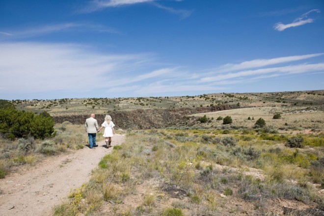 Michelle and Jeff hold hands and walk along the slide trail towards the Rio Grande gorge