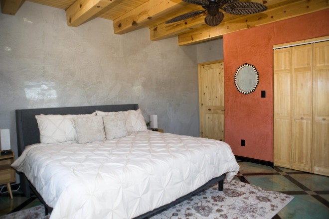 Southwest style bedroom with viga ceiling in El Prado home