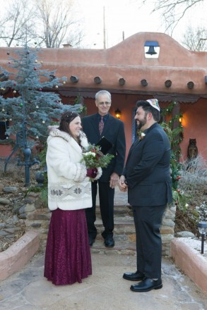 Small Jewish elopement in front of adobe bed and breakfast in Ranchos de Taos