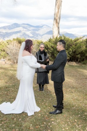 Maya and Robert are married in the afternoon with Taos mountain in background.