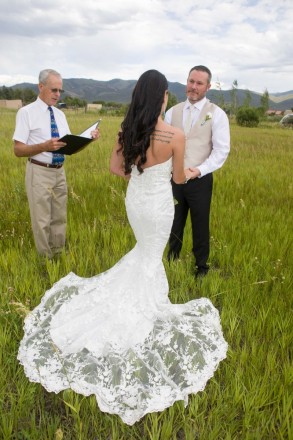 Mountain wedding with green meadows, open skies, and mountain views