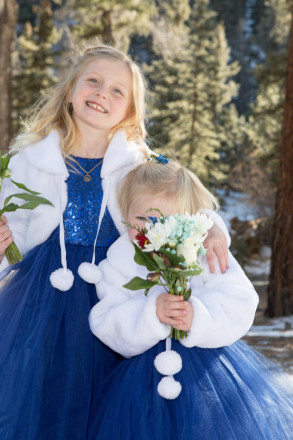 Flower girl playing Peek-a-boo with photographer at wedding