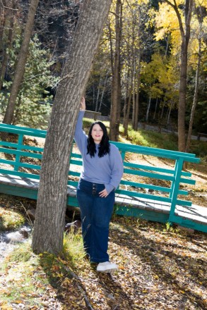 Katy stands with turquoise bridge for her senior photos in Red River, NM