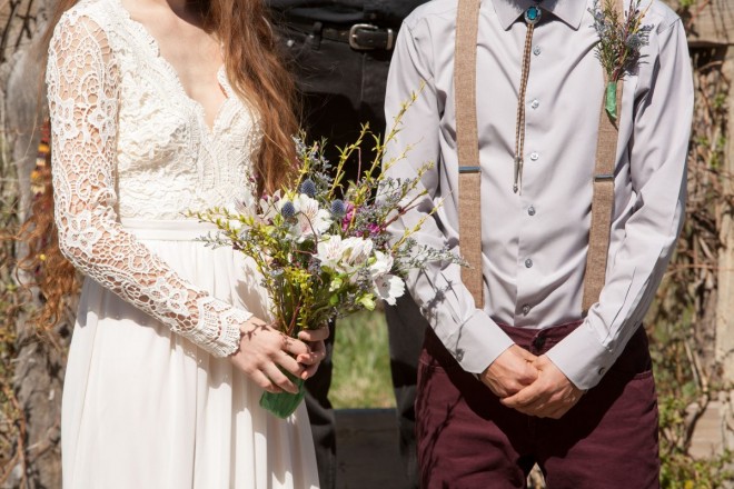 Garden bouquet and a turquoise bolo tie and lace wedding dress sleeves