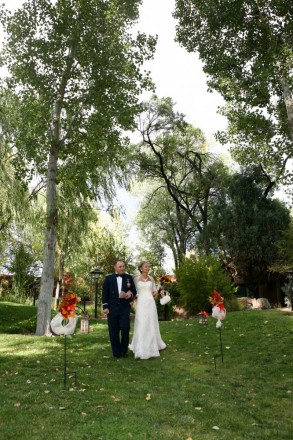 A wedding aisle with green grass and cottonwood trees in Taos NM
