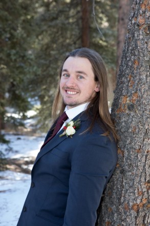 Pinetrees and snow adorn the background of this Red River groom