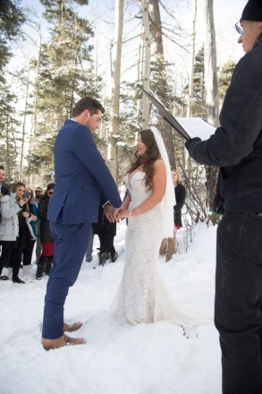 Kiersten and Andrew recite a prayer during their outdoor snowy wedding