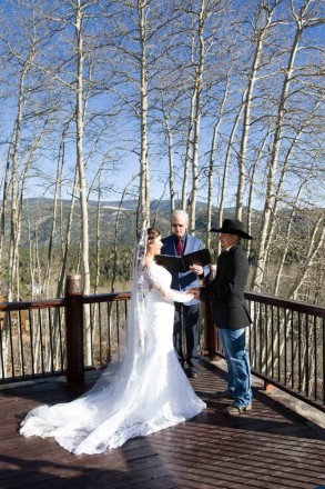 Alysa and Ty smile at each other during their wintertime wedding, outside.