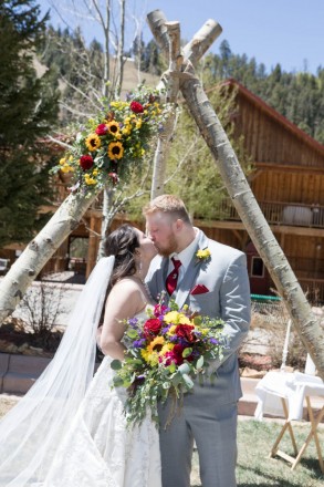 Jordan and Ashleigh kiss in front of their tipi altar in Red River, NM