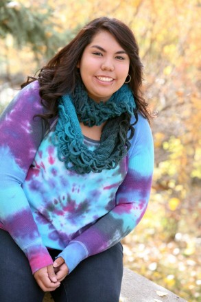 Soon to be graduate smiles in tie-dye for her Taos high school senior photos