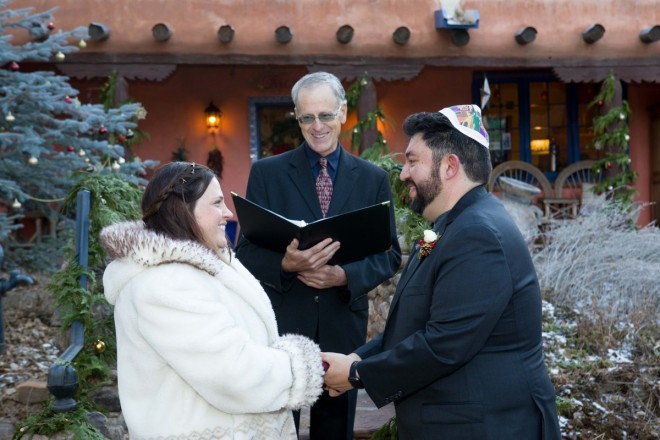 The wedding couple share a smile with their officiant during their New Mexico elopement