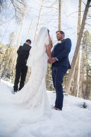 The brides white dress blends perfectly into the white snow at this outdoor wedding