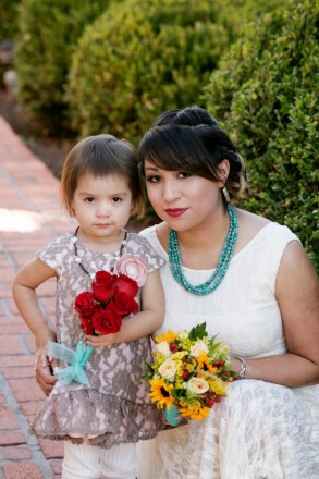 Espanola bride wearing turquoise and flowergirl with red roses