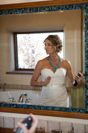 Chasity sprays her hair to prepare for the dry Taos air at her outdoor wedding ceremony