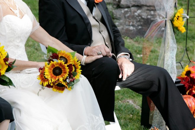 The bride and groom, also best friends, hold hands during the wedding ceremony sermon
