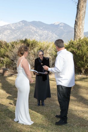 Rosie and Phil wore white to their December wedding, officiant dressed in black