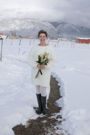 Bride with lilies and white crocheted dress with Taos mountain