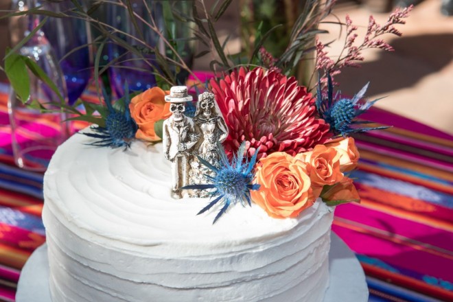 Wedding cake with El Dia de Los Muertos cake topper with flowers