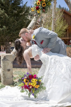 Ashleigh an Jordan kiss during a dip in front of their wedding altar