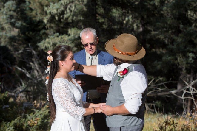 Edwardo touches his wife during their outdoor October wedding in the woods