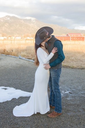 Romantic kiss to keep warm at December Taos wedding