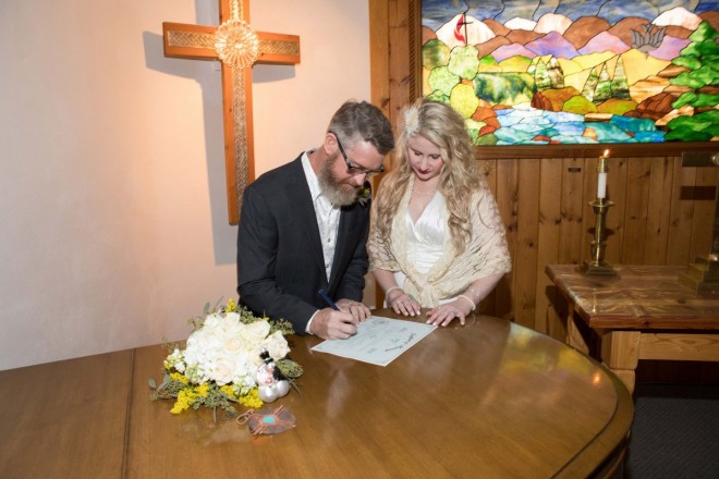 Newlyweds sign marriage certificate at small wedding at El Publito Methodist Church