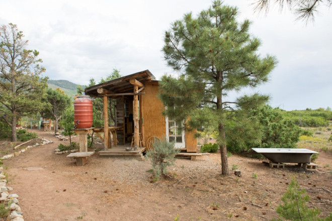 Outhouse, fire heated bathtub, and water catchment in Lama, NM