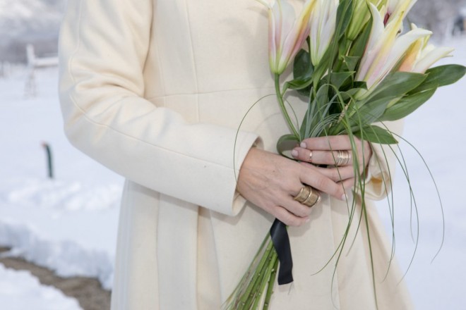 Bride's hands, cold and in gold, hold her lily bouquet on the first day of 2022