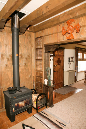 Word burning stove and front hallway of small Taos cabin