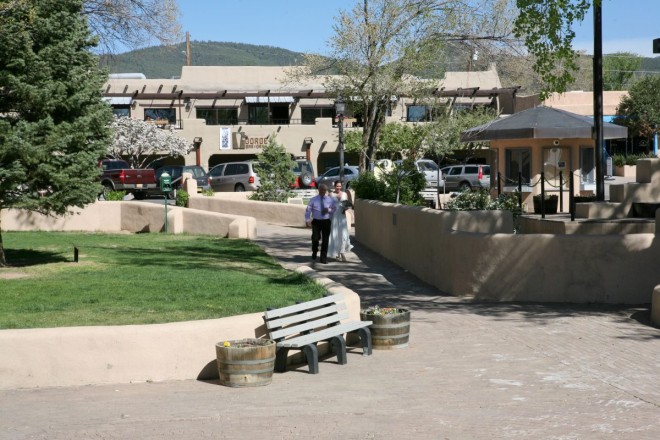 Proud father of the bride walks his daughter to the gazebo through the Taos plaza