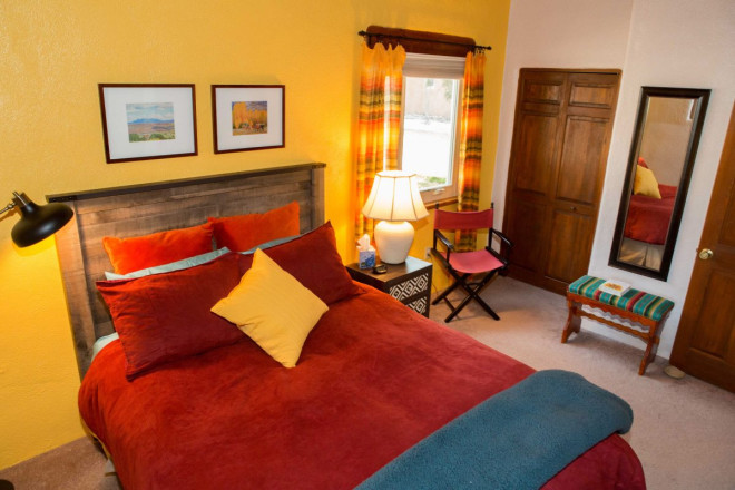 Bedroom with gold wall and southwest colors of decor in Taos condo