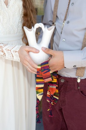 Close up details of wedding vase, hand fasting sash, bolo tie, and her wedding ring