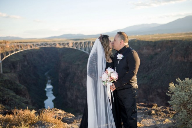 Shirley and Fernando kiss with the Rio Grande Gorge and Rio Grande as a backdrop
